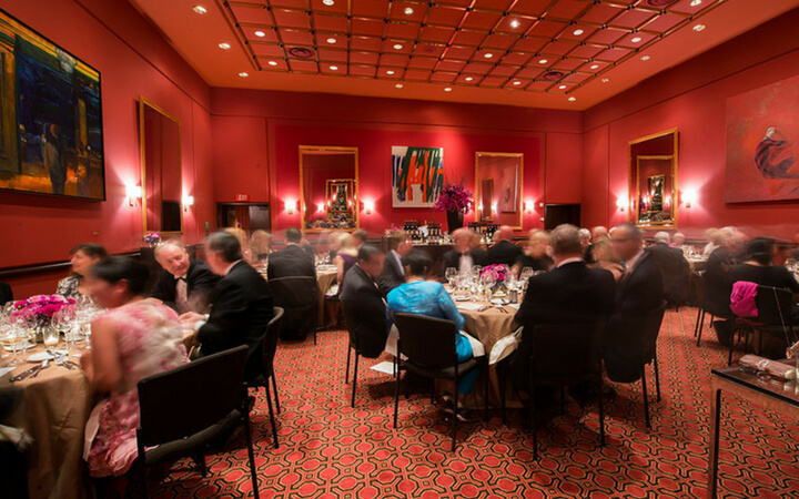 An event unfolding at the Wattis Room in San Francisco surrounded by red walls and art