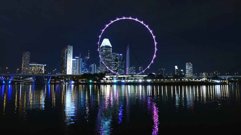 The Singapore skyline at night exemplifies the draw of a first-tier city